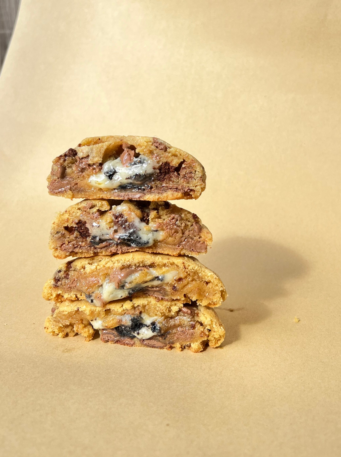 Stack of three cookies and cream cookies on a beige background